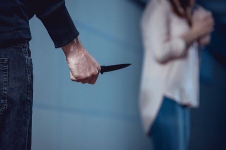 selective focus of thief with knife standing near womanの写真素材