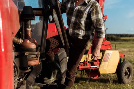 selective focus of self-employed farmer standing near modern tractorの写真素材