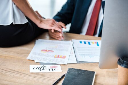 cropped view of man and woman holding hands in officeの写真素材