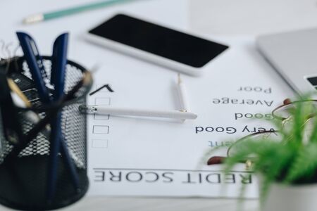 selective focus of credit score, smartphone, stationery and broken pencil