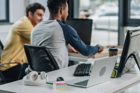 back view of african american programmer working in office together with colleague