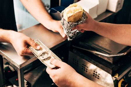 cropped view of man buying doner kebab in aluminium foilの写真素材