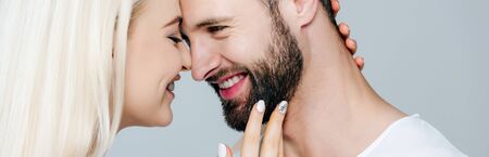 panoramic shot of beautiful girl embracing man and smiling isolated on grey
