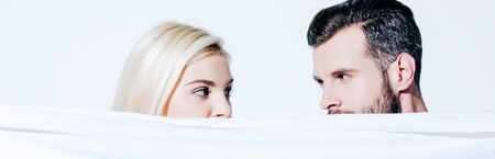 panoramic shot of girlfriend and handsome boyfriend holding blanket isolated on whiteの写真素材