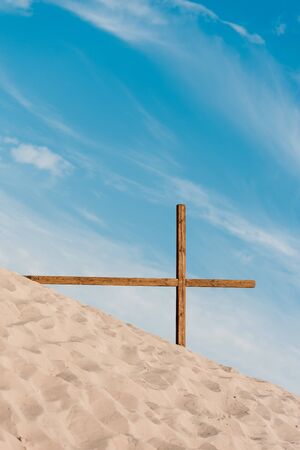 wooden cross on golden sand in desertの写真素材