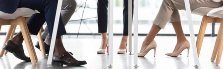 panoramic shot of multiethnic businesspeople in formal wear sitting in office