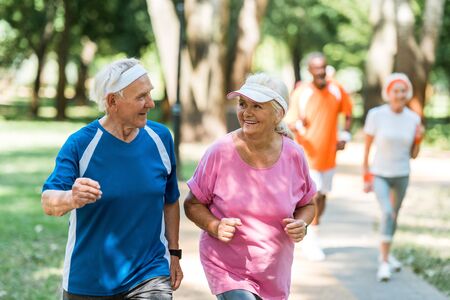 selective focus of positive senior couple exercising outsideの写真素材
