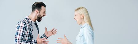 panoramic shot of man and woman shouting and gesturing isolated on grey