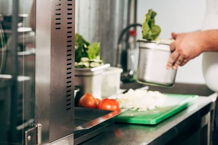 cropped view of cook holding container in kitchen