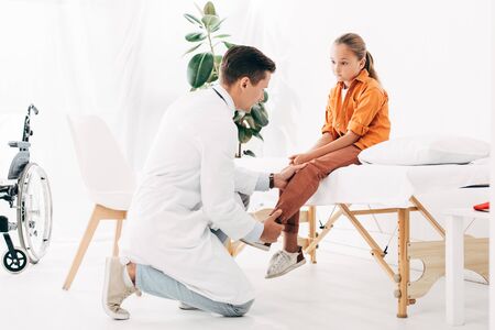 pediatrist in white coat examining child in clinic