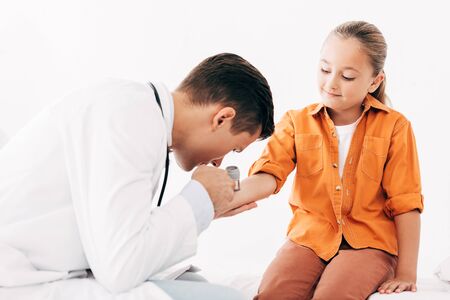 pediatrist in white coat examining child with dermascopeの写真素材