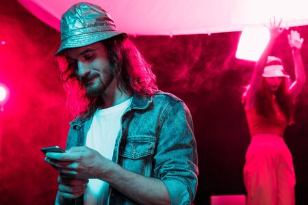man using smartphone during rave party in nightclubの写真素材