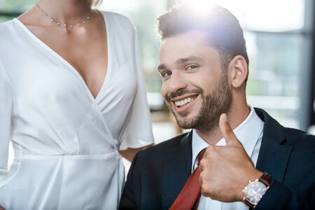 cropped view of woman near cheerful businessman showing thumb upの写真素材