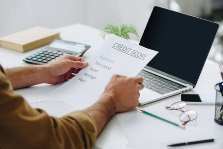 cropped view of man holding credit score in apartmentの写真素材
