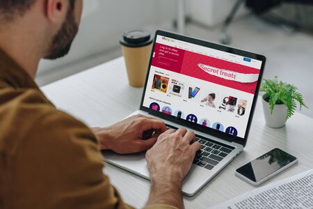 cropped view of man using laptop with ebay website on screenのeditorial素材