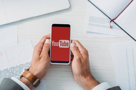 top view of man holding smartphone with youtube appのeditorial素材