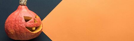 panoramic shot of Halloween pumpkin on black and orange background