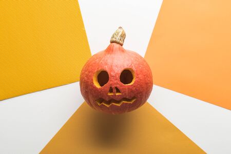 top view of Halloween pumpkin on white and orange backgroundの写真素材