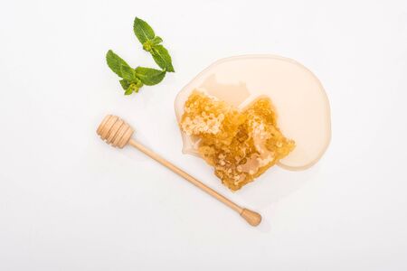 top view of honey, mint, honeycomb and wooden honey dipper on white backgroundの写真素材