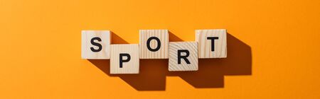 panoramic shot of wooden blocks with sport lettering on yellowの写真素材