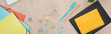 panoramic view of stationery, folders and notepads on wooden table