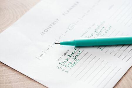 selective focus of monthly planner with green pen