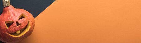 panoramic shot of Halloween pumpkin on black and orange background