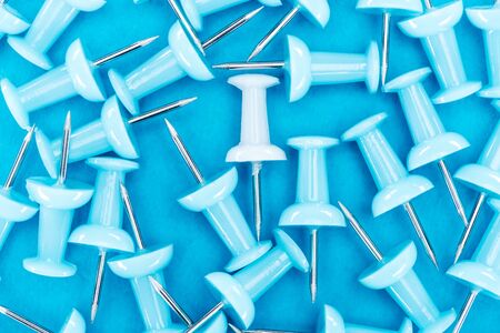 top view of white paper clip in pile of blue paper clips, violence concept