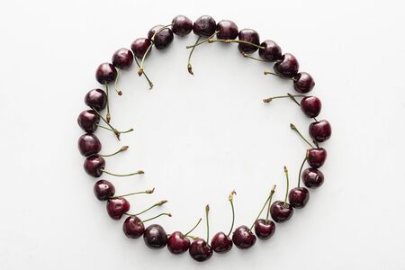 flat lay with fresh, whole and ripe cherries covered with water drops