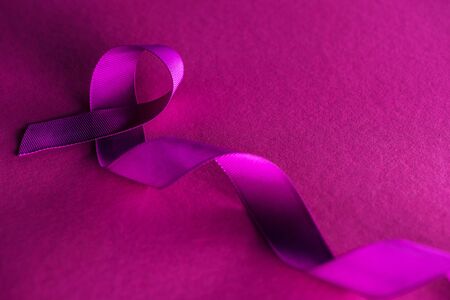 purple ribbon on pink background with shadow, violence conceptの写真素材