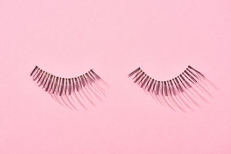 top view of false eyelashes on pink background with copy spaceの写真素材