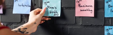cropped view of woman holding in hand colorful sticker pad with notes