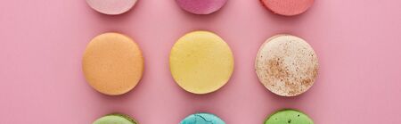 flat lay with multicolored delicious French macaroons on pink background, panoramic shotの写真素材