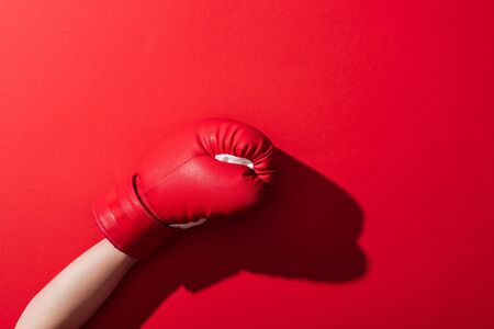 cropped view of woman in boxing glove on redの写真素材