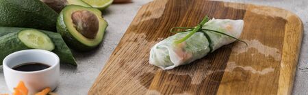 panoramic shot of spring roll on cutting board with onion among ingredientsの写真素材