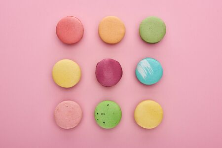 flat lay with delicious French macaroons on pink background