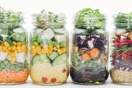 fresh vegetable salad in glass jars isolated on white