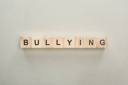 top view of wooden blocks with bullying lettering on grey backgroundの写真素材
