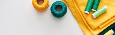 panoramic shot of fabric, knitting yarn balls and threads on white backgroundの写真素材