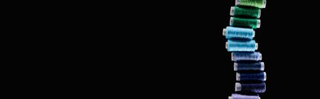 panoramic shot of bright and colorful threads isolated on black