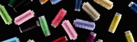 panoramic shot of bright and colorful threads isolated on black