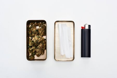 flat lay with metal box with marijuana buds and rolling paper near lighterの写真素材