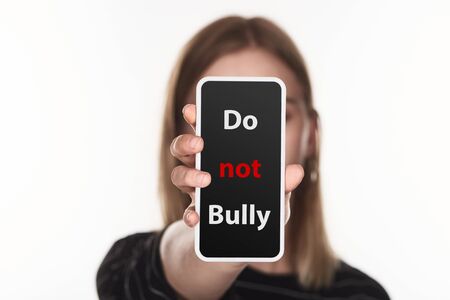 selective focus of victim of cyberbullying showing smartphone with do not bully lettering on screen isolated on whiteの写真素材