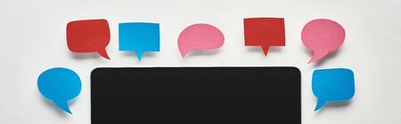 panoramic shot of laptop with blank screen on white background with empty speech bubbles around...