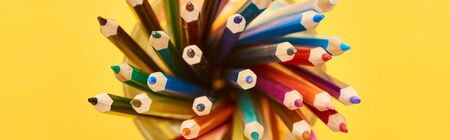 Panoramic shot of sharpened and bright color pencils isolated on yellowの写真素材