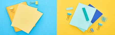 Top view of yellow and blue notepads near paperclips on bicolor background