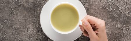 top view of woman holding matcha matcha tea in cup