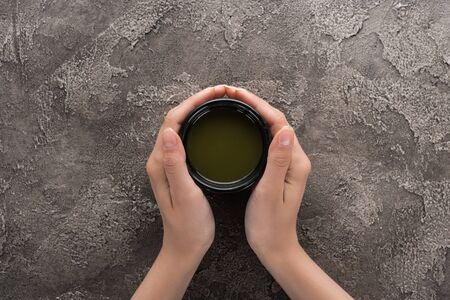 top view of woman holding matcha matcha tea in handsの写真素材