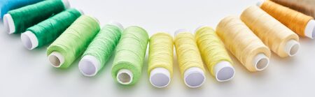 panoramic shot of bright and colorful threads on white backgroundの写真素材