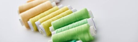 panoramic shot of bright and colorful threads on white background
